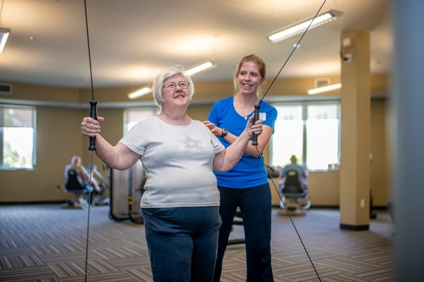 Resident participating in a fitness activity with support