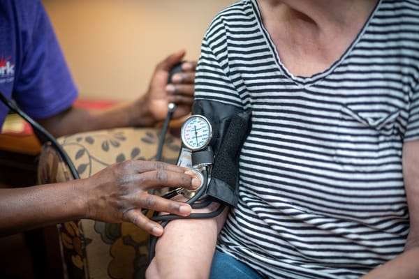A staff member checking a resident's blood pressure
