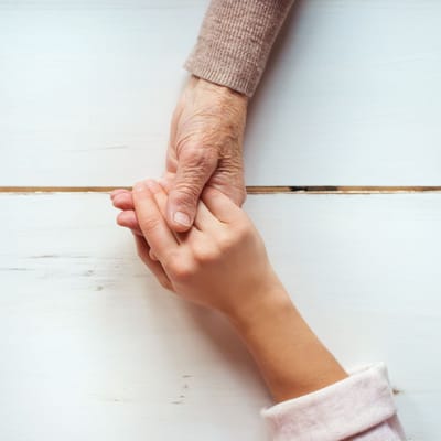 Two hands holding each other on a table