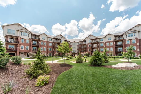 Exterior view of a senior living facility with gardens