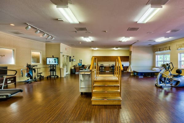 Rehabilitation therapy room with equipment and stairs