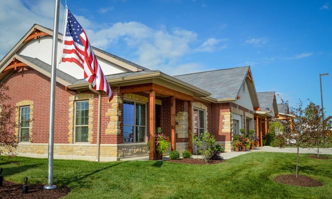 Exterior view of a senior living facility with American flag