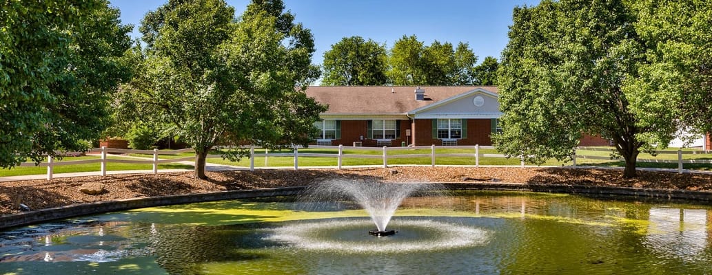 The exterior of The Rehabilitation Center of Independence with a pond