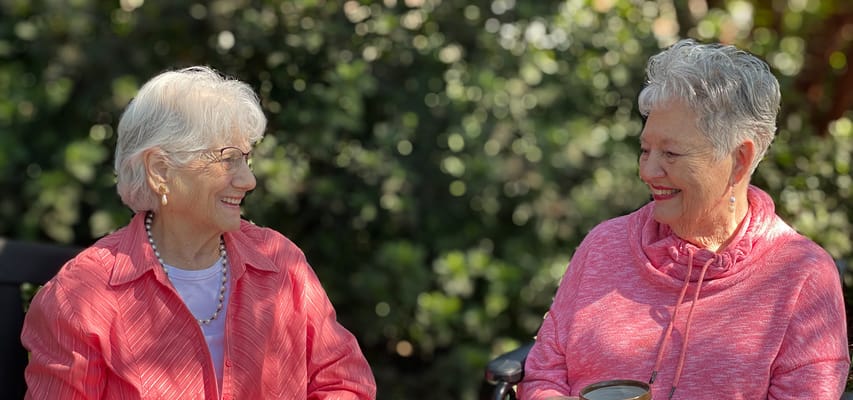Two residents enjoying a conversation outdoors