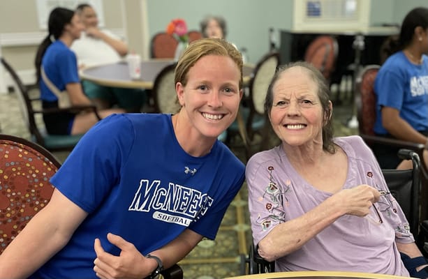 Resident enjoying time with a volunteer in a common area