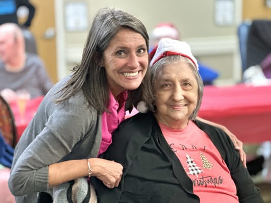 Staff member posing with a resident during a celebration
