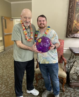 Residents enjoying a festive activity with leis and a ball