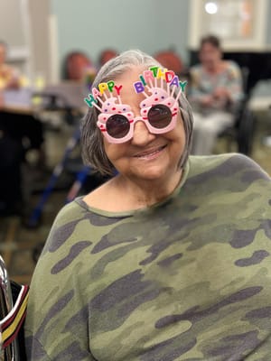 Resident celebrating a birthday with festive glasses