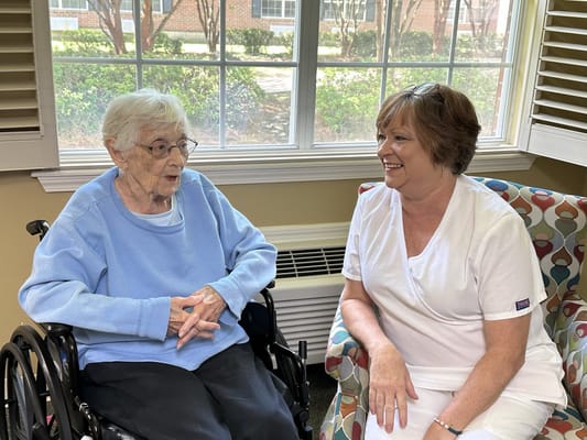 Resident and staff member talking in a cozy lounge
