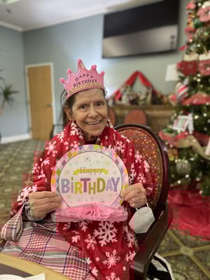 Resident celebrating a birthday with a colorful sign