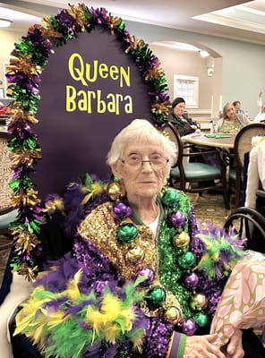 Resident dressed for celebration in a decorated chair