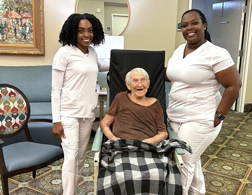 Two staff members with a resident in a common area
