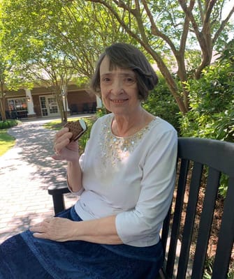 A resident enjoying an ice cream sandwich in the garden