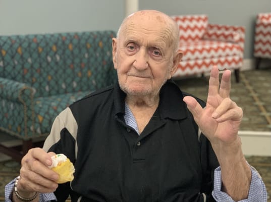Resident enjoying a pastry in a common area