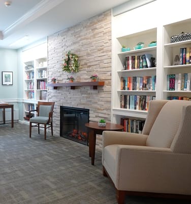 Interior seating area with a cozy fireplace and bookshelves