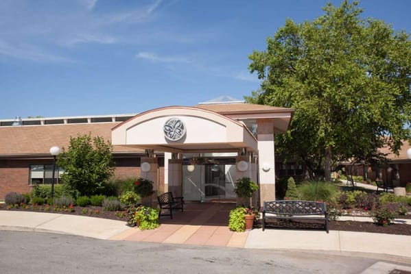 Entrance of a senior living facility with a garden
