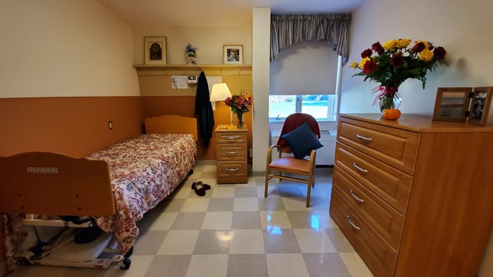 Cozy resident room with bed, chair, and decoration