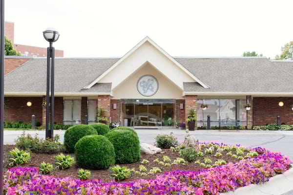 Exterior view of Delmar Gardens with flowers and landscaping