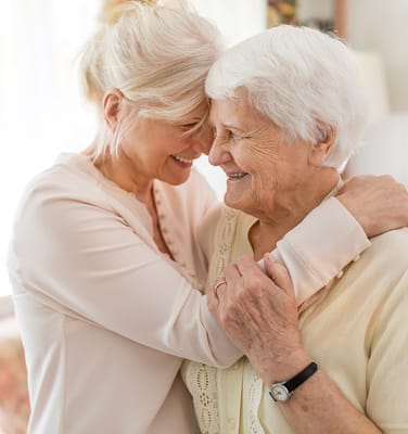 A caregiver and resident sharing a warm embrace