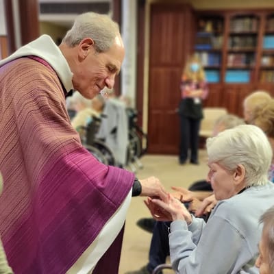 A staff member assisting a resident in a common area.