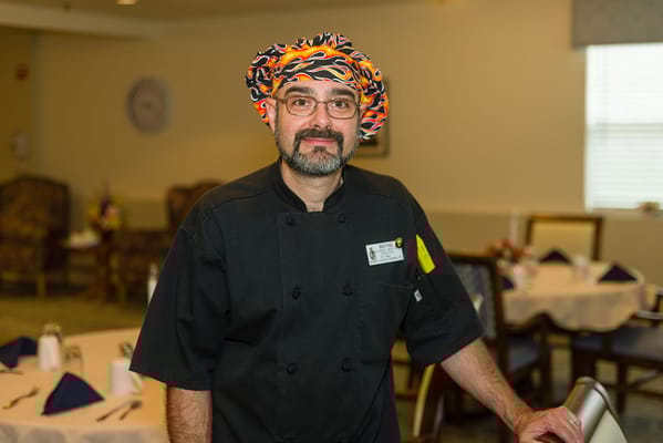 Chef standing in the dining area of the facility