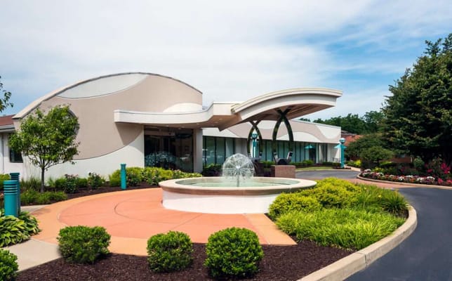Exterior view of a senior living facility with a fountain