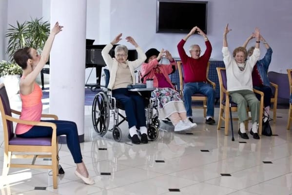 Residents participating in a seated exercise class indoors