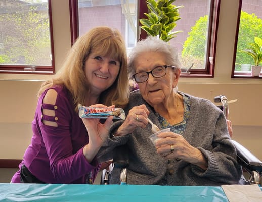 Resident enjoying ice cream with staff member