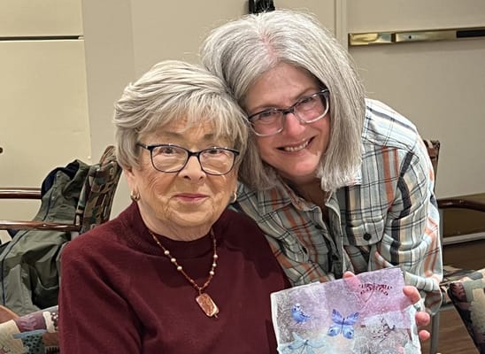 Resident and staff member smiling together