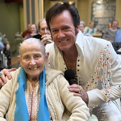 Resident with entertainer in a vibrant activity room