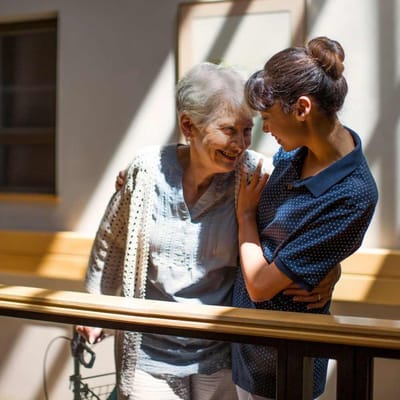 Staff member interacting warmly with a resident indoors