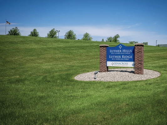 Exterior sign of Luther Crest Apartments with green grass