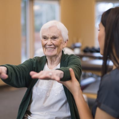Senior resident participating in physical therapy with a caregiver