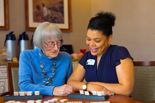 Resident and staff member engaging in a game together