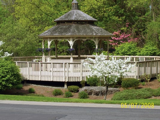 Outdoor gazebo surrounded by greenery and flowers