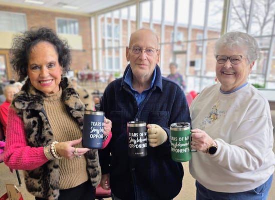 Residents celebrating with personalized mugs in a common area