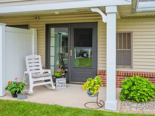 Cozy porch area with flowers and a chair