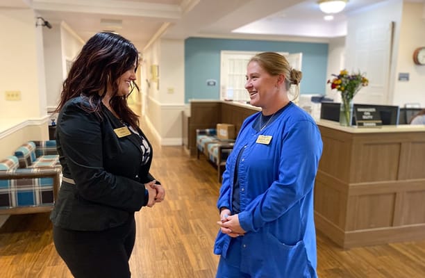 Two staff members conversing in a common area