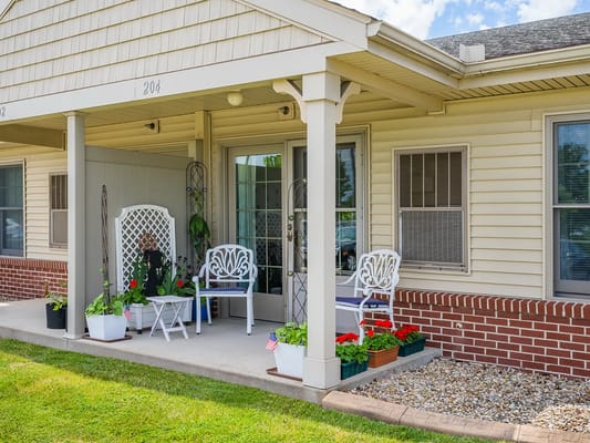 A welcoming porch with chairs and flower pots