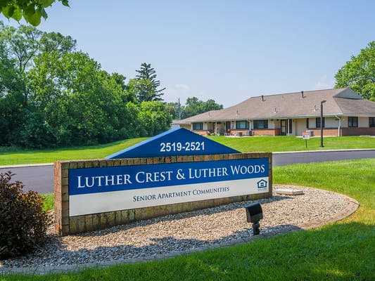 Sign for Luther Crest Apartments with building in background