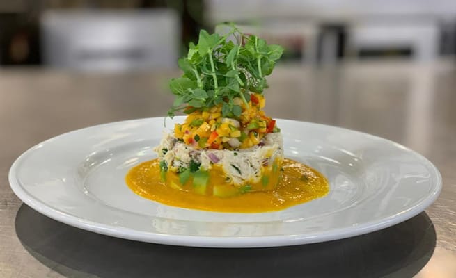 Plated gourmet meal with colorful vegetables on top
