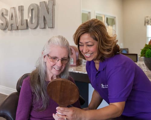 A staff member assisting a resident in the salon