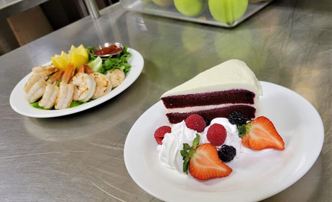 Plated meal featuring shrimp and dessert