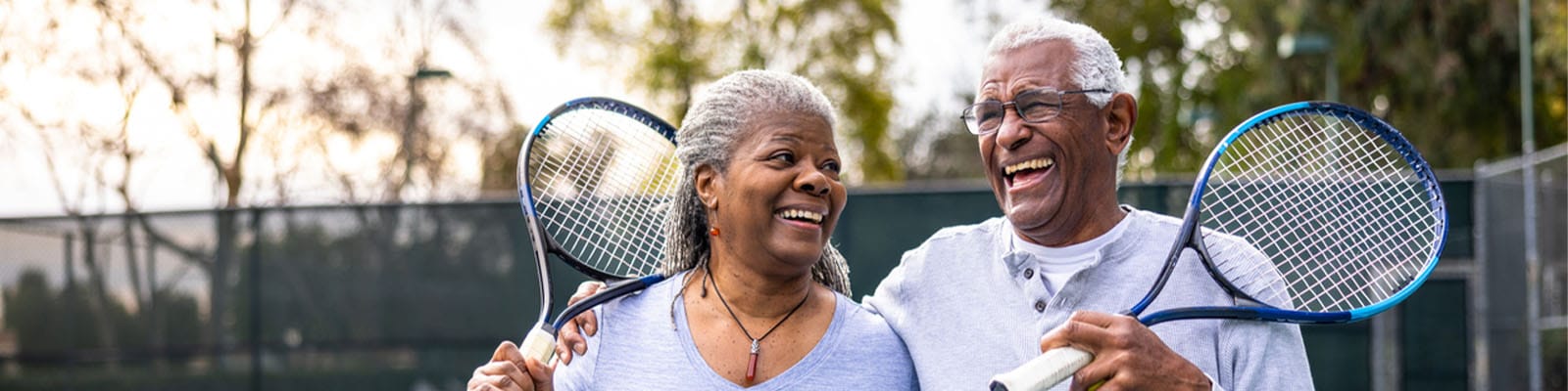 Two seniors enjoying tennis on an outdoor court