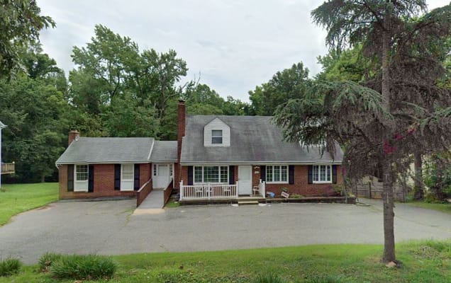 Exterior view of a brick building surrounded by greenery