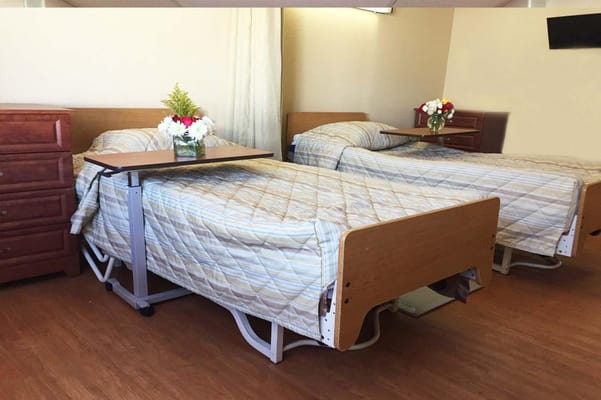 Private resident room with two beds and flowers