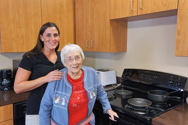 Staff member assisting a resident in the kitchen