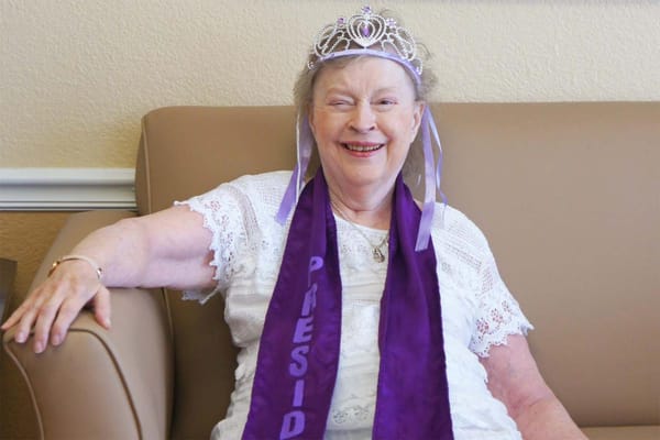 Resident celebrating as president with a crown and sash