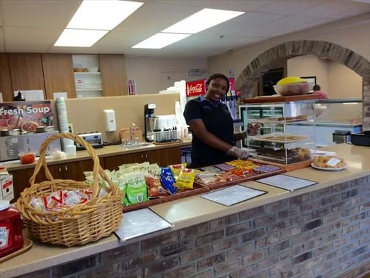 Staff member serving food at an assisted living facility kitchen