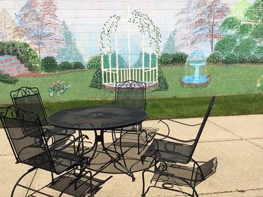 Outdoor seating area with a mural backdrop